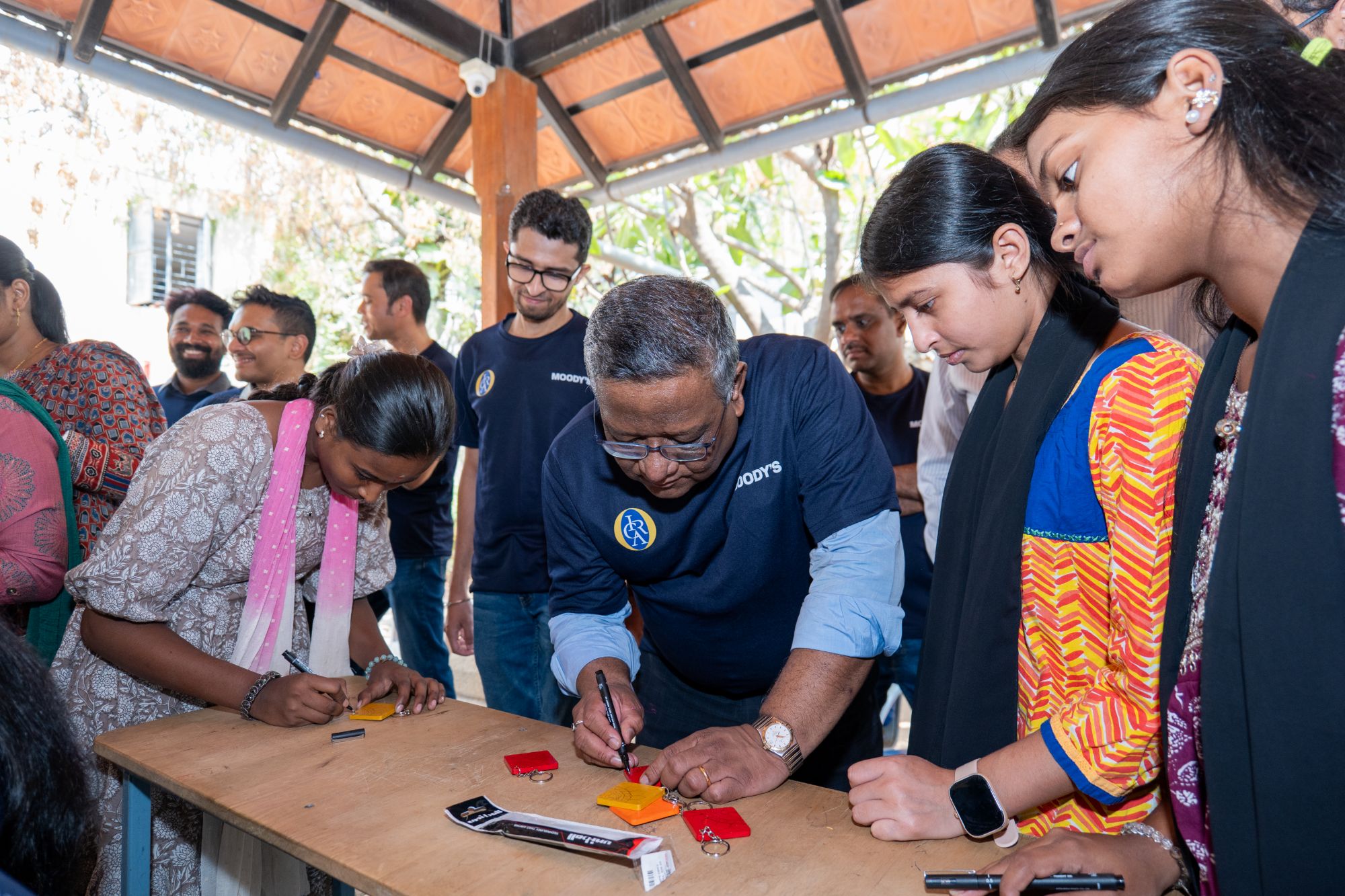 Volunteers and students painting keychains together at a craft activity